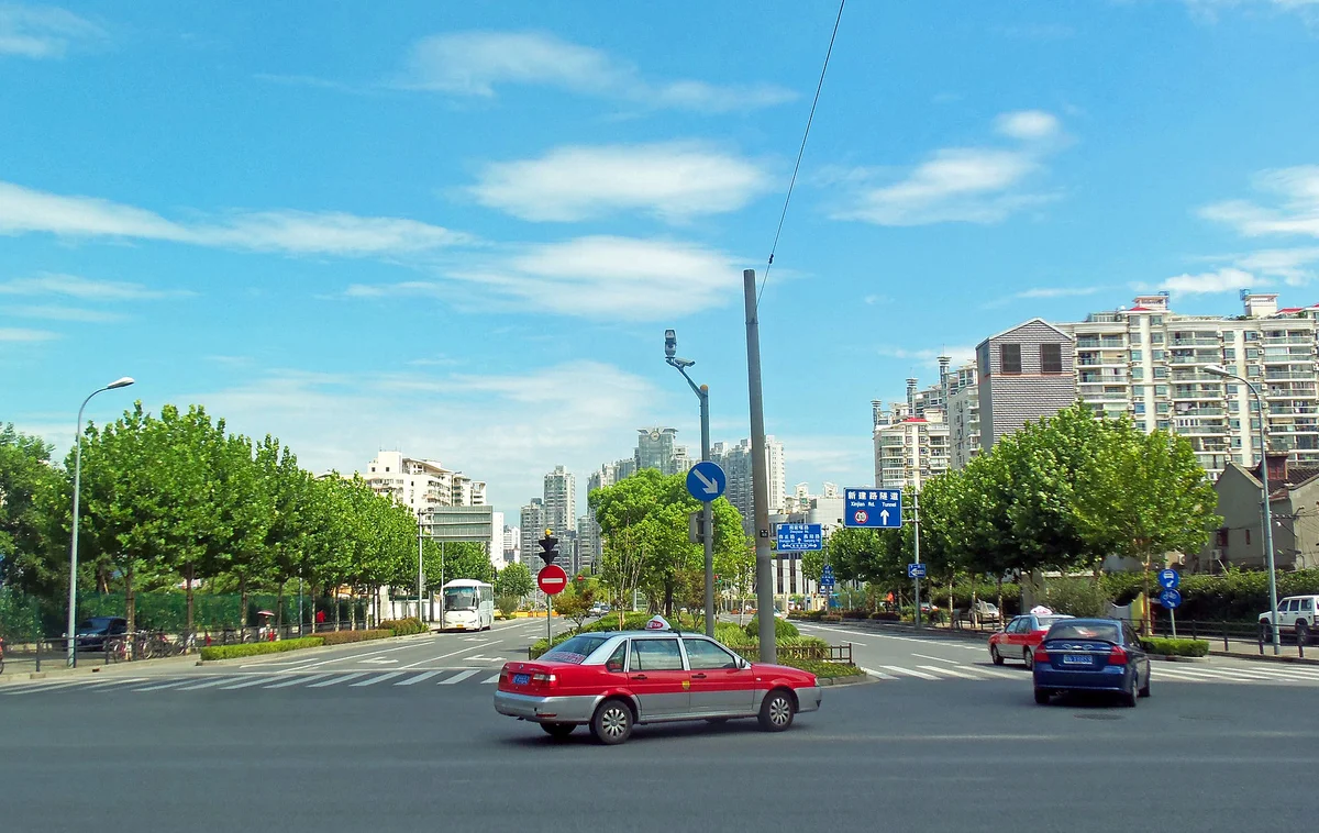 上海の街を走る赤いタクシー。中国の都市部ではタクシー配車アプリDiDiが移動の主役になっている
