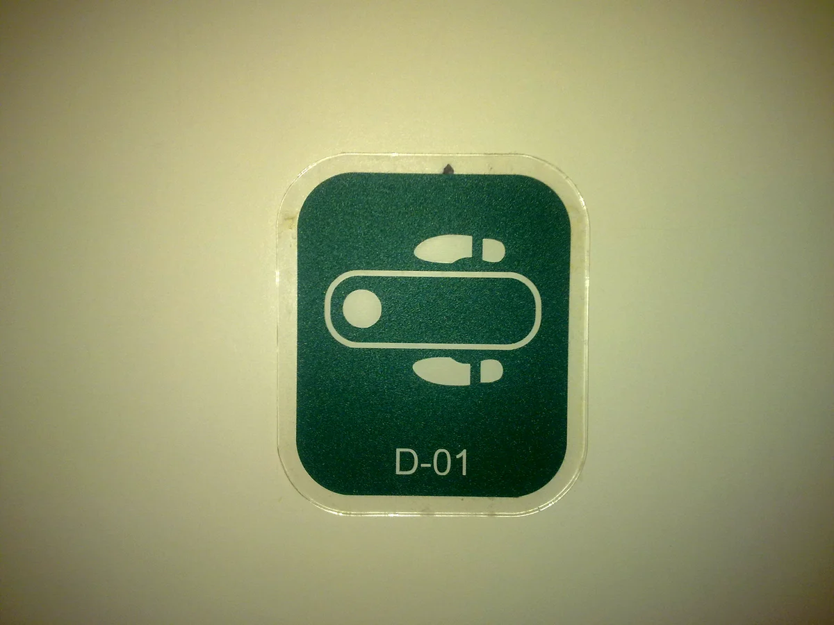 中国のトイレに貼られた蹲便器（和式）のマーク。足の形が描かれている