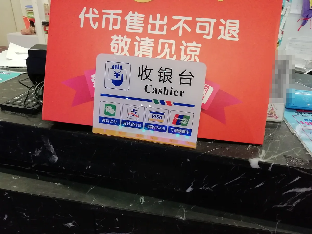 中国の店のレジに置かれた微信支付（WeChat Pay）・支付宝（Alipay）・Visa・銀聯の対応表示
