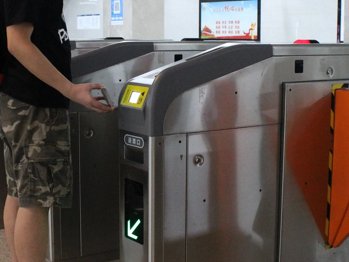 中国の地下鉄の改札でスマホのQRコードをかざして通る様子。乗車コードはAlipayの中で出せる