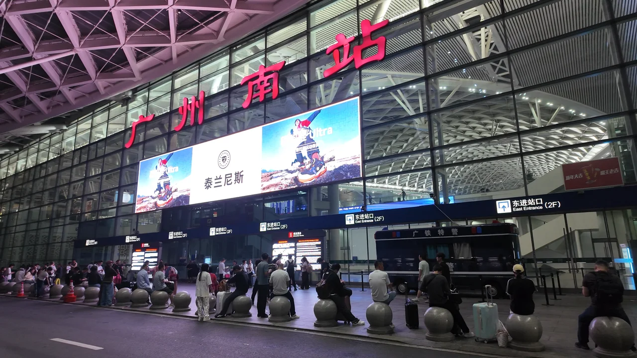 広州南駅の外観 — 早朝の駅前で開門を待つ乗客たち